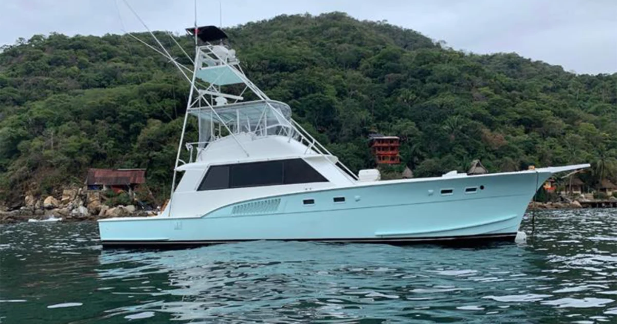 The 54 ft Hatteras sportfisher with its tuna tower off the green hills of Nuevo Vallarta
