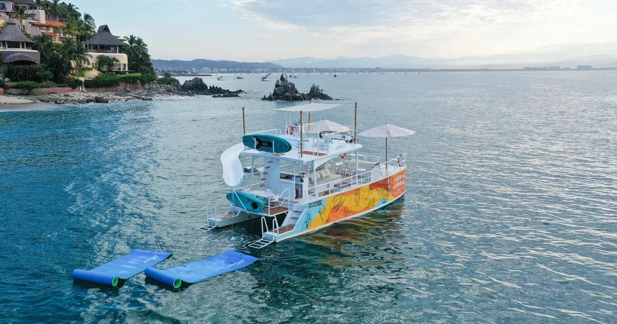 The 45 ft party catamaran with a waterslide anchored near Los Arcos on a Puerto Vallarta group charter